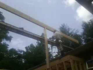 Carpenter setting a ridge beam over a new addition frame — Ice Dam Removal by Roofing Brothers in La Ward