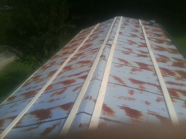 Rusted metal roof panels with new wood purlins before replacement — Storm Damage Roof Repair in La Ward by Roofing Brothers