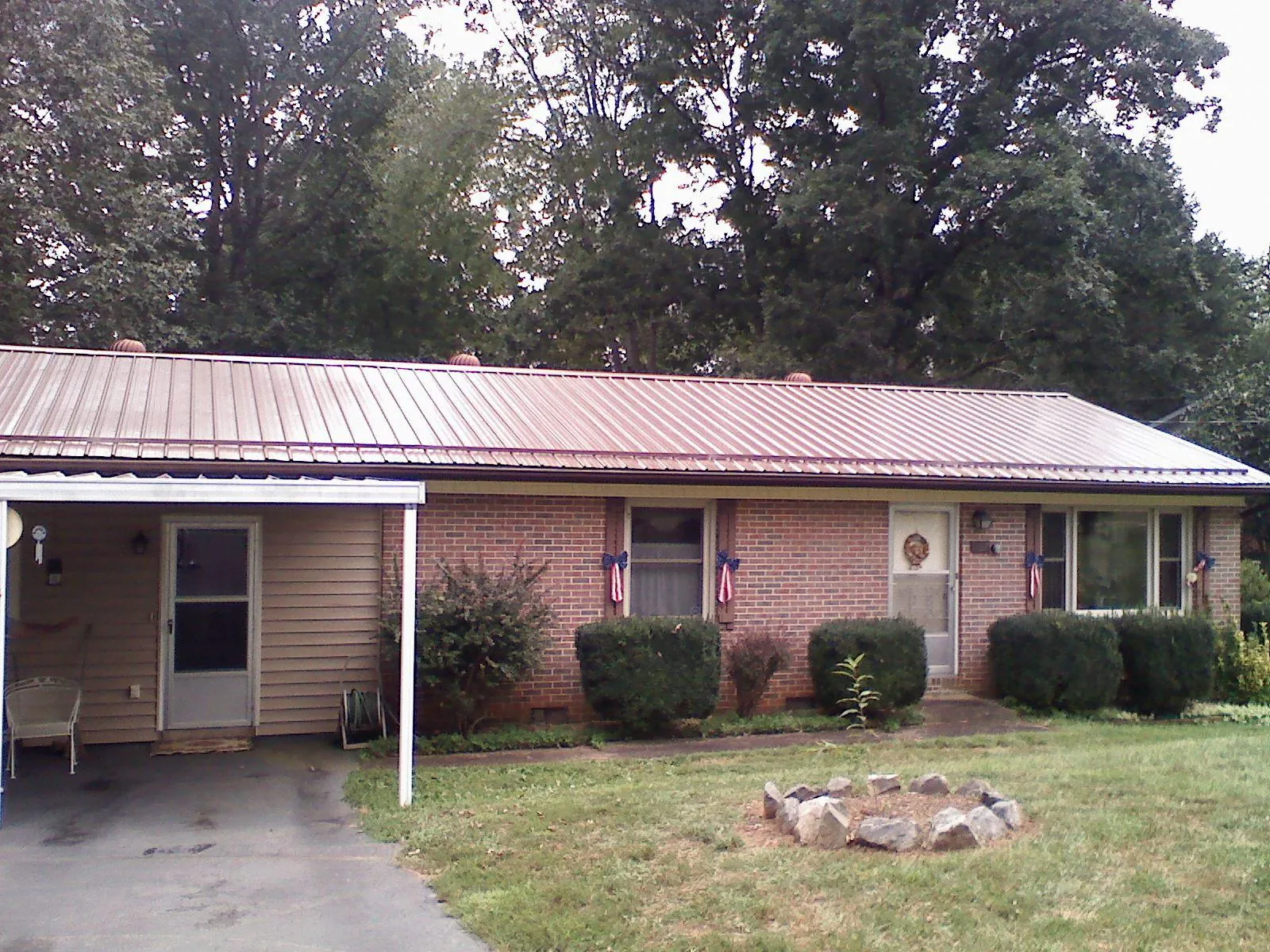 Bronze metal roof and carport on a brick ranch home — Roof Repair work by our crew in La Ward